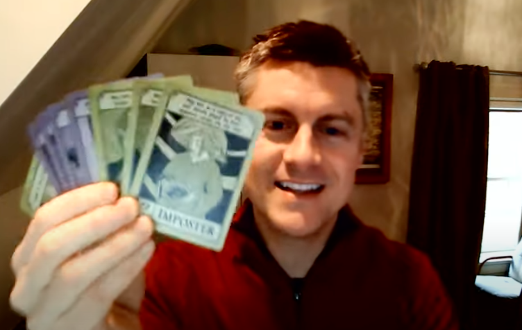 Jamey Stegmaier (prolific designer and publisher of board games Scythe, Viticulture, and Wingspan) smiling and holding up cards from my game, Hierarchy