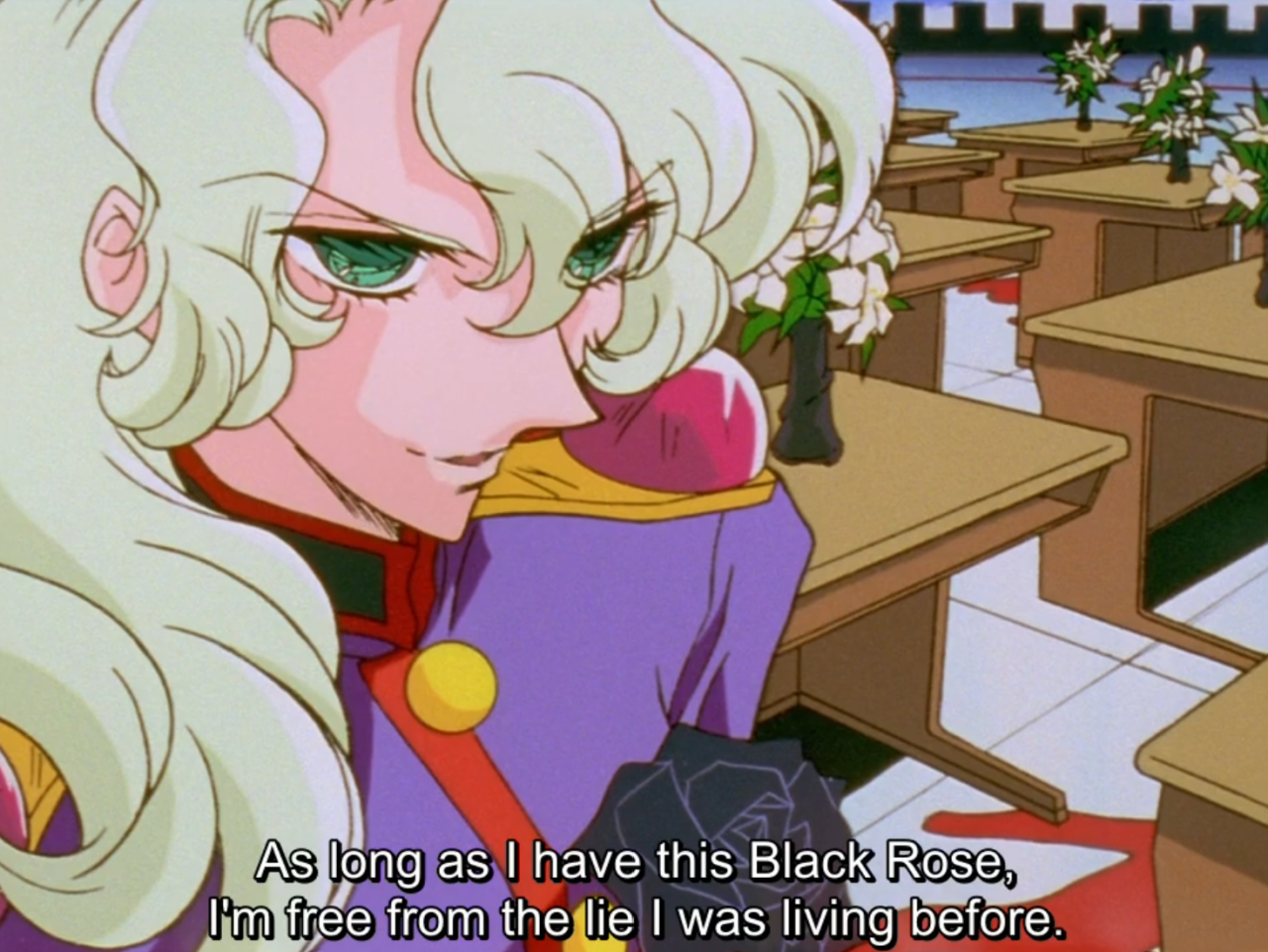 Kanae, in a purple duelling outfit, glances back over her shoulder with a sly smile, holding a black rose, in a classroom with white flowers in vases on the desks. The subtitle reads “As long as I have this Black Rose, I’m free from the lie I was living before.”