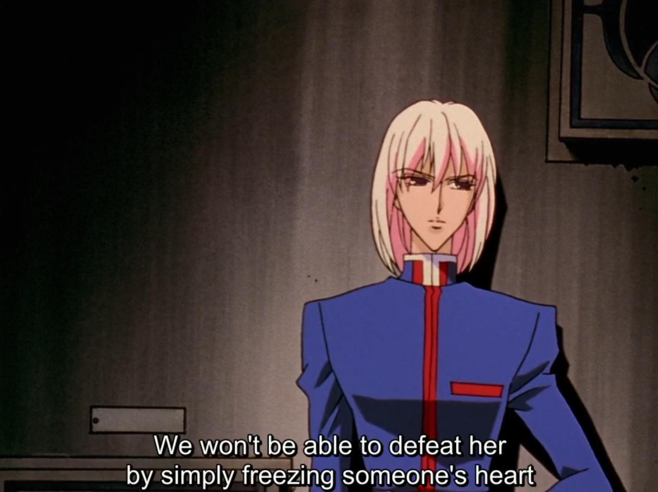 Mikage, with a pale pink bob and a blue high-collared uniform, stands in a dim room looking coolly ahead. The subtitle reads “We won’t be able to defeat her by simply freezing someone’s heart”
