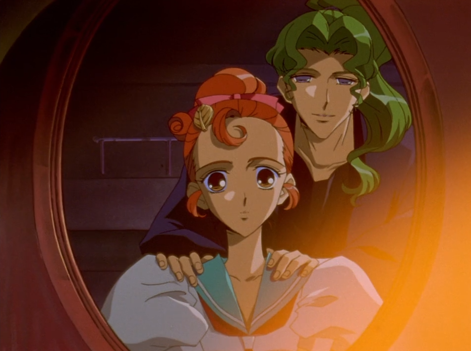 Wakaba, wearing a leaf-shaped hair clip, looks into an oval mirror while Saionji stands behind her with his hands on her shoulders.