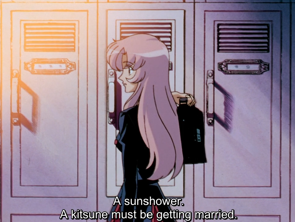 Utena, holding her school bag, glances back over her shoulder in front of a row of shoe lockers. The subtitle reads “A sunshower. A kitsune must be getting married.”