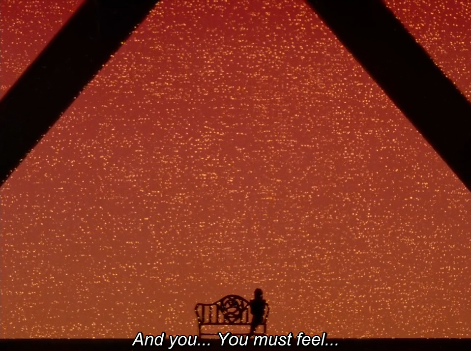 A tiny silhouetted figure stands beside an ornate bench beneath dark crossing beams, against a vast glittering orange-red background. The subtitle reads "And you... You must feel..."